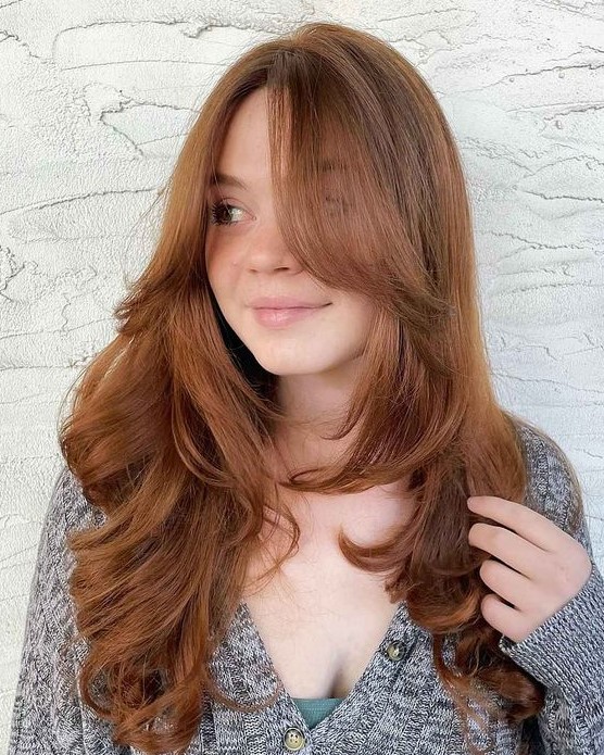 long ginger hair with curtains bangs and curved ends plus a lot of volume is a fab idea