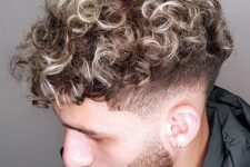 losse blonde curls with low taper and a beard look daring and cool, and curly texture makes them edgy