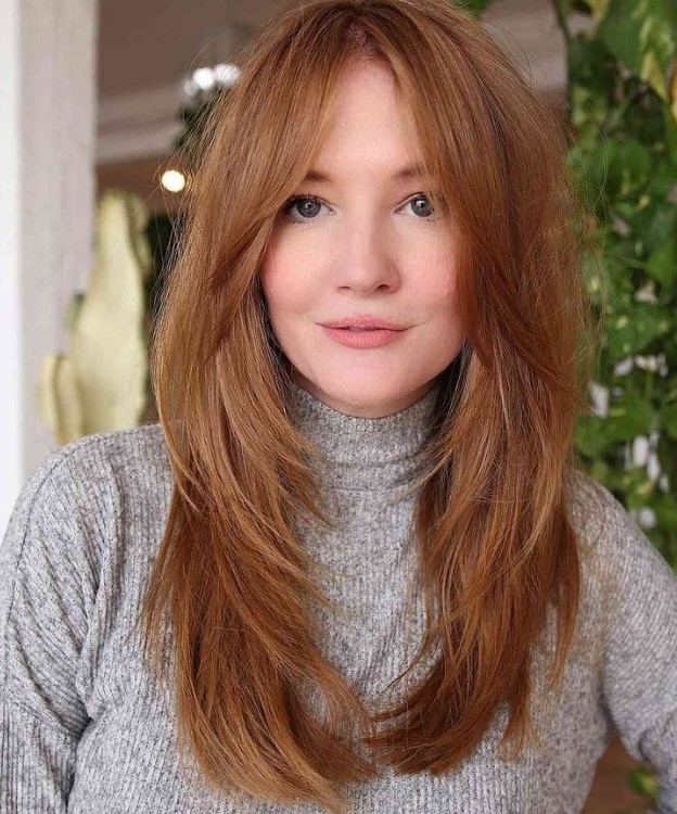 lovely ginger hair with a butterfly haircut, with curtain bangs looks very beautiful and very chic
