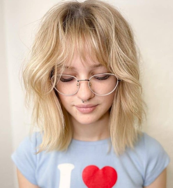 this blonde hairstyle with long bangs is one of the most romantic forms of the wolf cut, and the soft shade adds to it