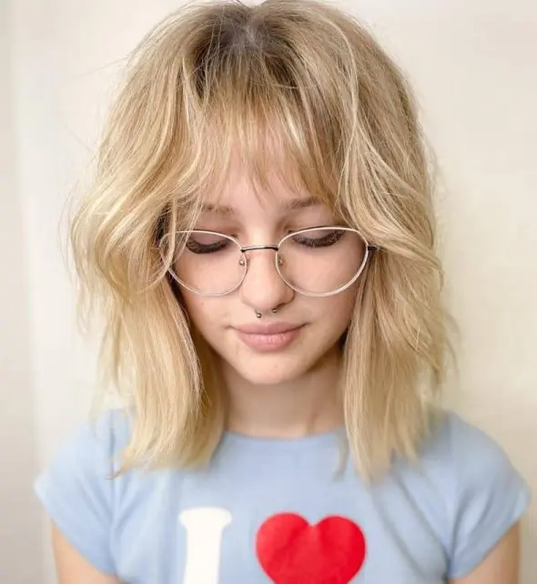 this blonde hairstyle with long bangs is one of the most romantic forms of the wolf cut, and the soft shade adds to it