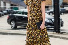 08 a bold and chic fall wedding guest look with a yellow, black and navy floral midi dress with a high neckline, ruffle cap sleeves, brown boots and a black clutch
