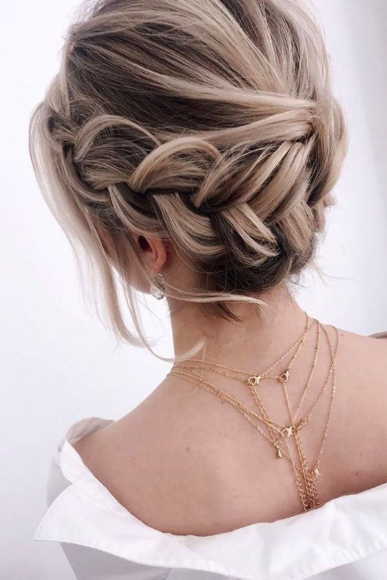 a braided halo low updo with a volume on top, some waves down is a lovely idea for a boho bride