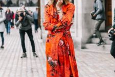 11 a bright orange midi dress with ruffles and a floral print, black booties are a super bold and catchy fall wedding guest look