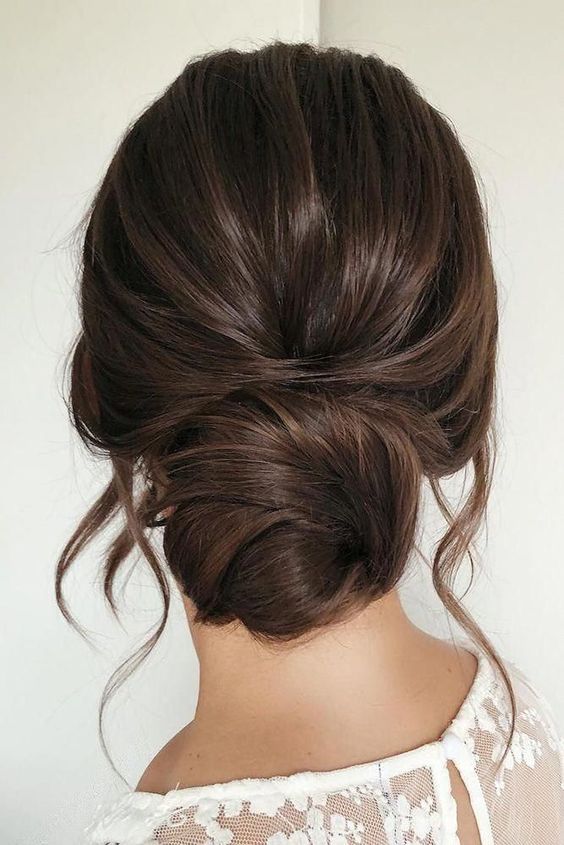 a classic twisted low bun with a volume on top and some face-framing hair is a catchy and stylish idea