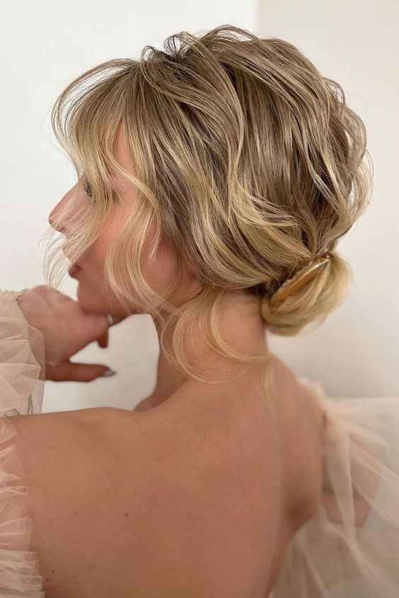 a dreamy wavy low bun with a messy wavy top and face-framing locks is a great idea for a mother of the bride with medium length hair