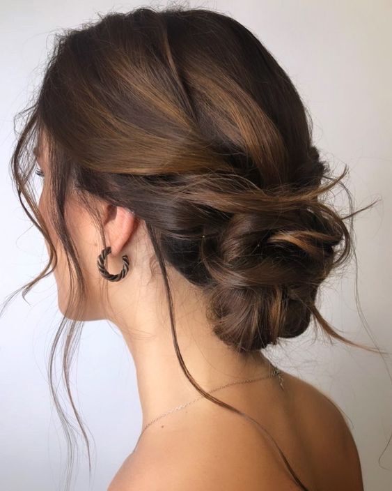 a messy low bun with an interwoven top and a twisted low bun, with some hair down is great for bridesmaid looks