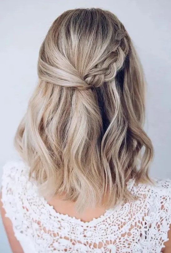 a pretty wedding half updo with a twisted and braided halo and waves down is ideal for medium length hair