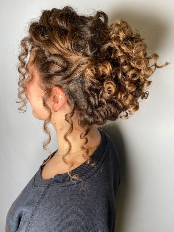 a curly updo with a curly top and some curls down to make it look more effortless is a chic idea