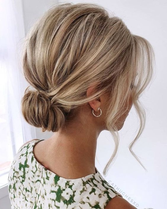 a pretty loose low bun with a bump on top and some locks framing the face is a stylish idea for a bridesmaid