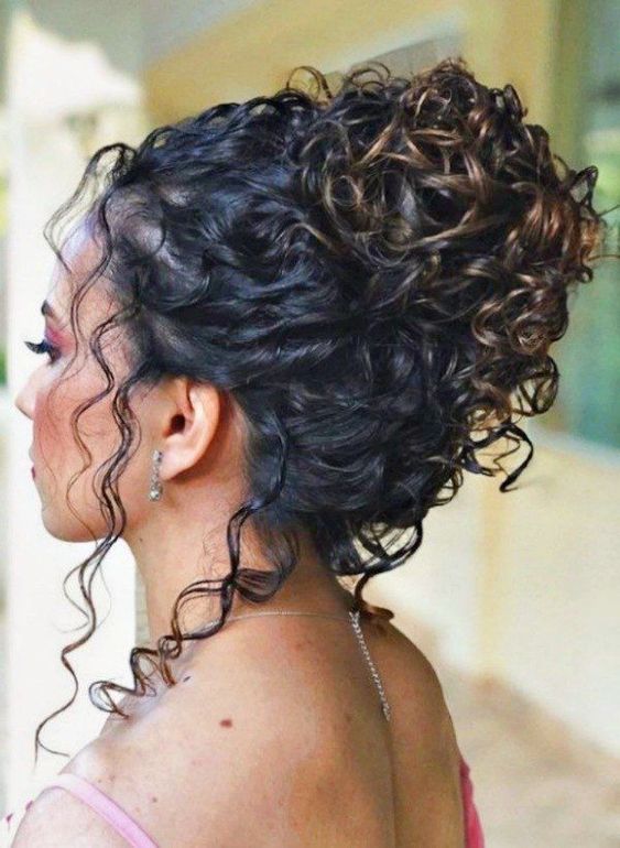 a curly updo with some curls down is a stylish idea for a wedding, such a top knot always works