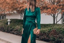 20 a dark green midi dress with a front slit, a high neckline, long sleeves, nude shoes and an embellished box clutch