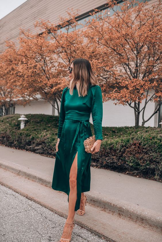 a dark green midi dress with a front slit, a high neckline, long sleeves, nude shoes and an embellished box clutch