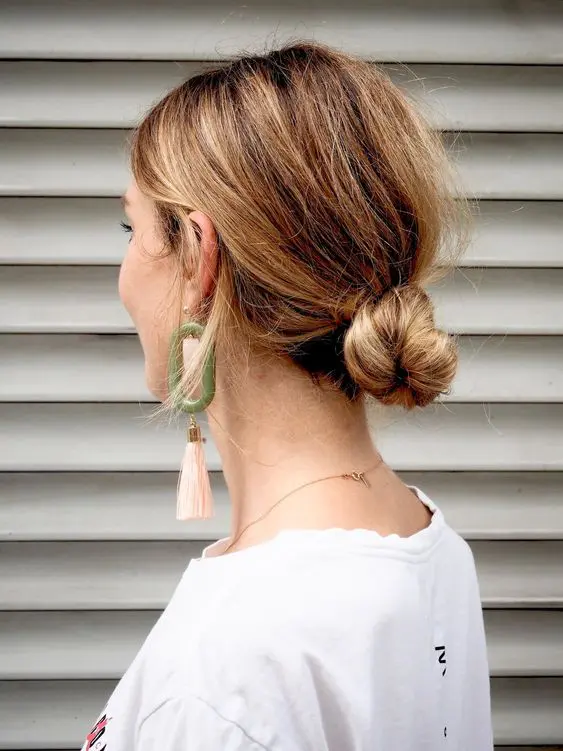 a messy twisted low bun with some volume is a cool and relaxed wedding hairstyle idea