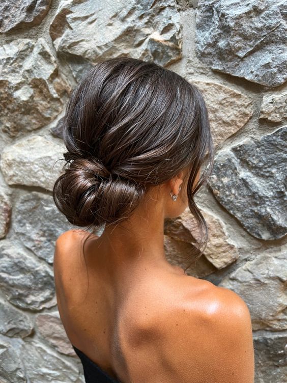 a simple twisted low bun with a bump on top and some waves down is a lovely idea for an effortlessly chic and cool look
