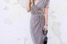 23 a grey wrap velvet dress with long ties, short sleeves, nude heels and a small black bag