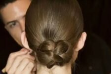 23 a sleek low updo with a braided bun is a cool and modern interpretation of a traditional low bun or chignon