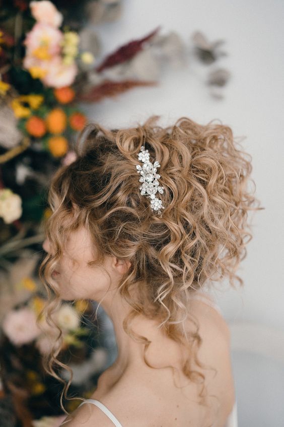 a lovely and relaxed curly updo with some curls down and an elegant rhinestone hairpiece on one side is amazing
