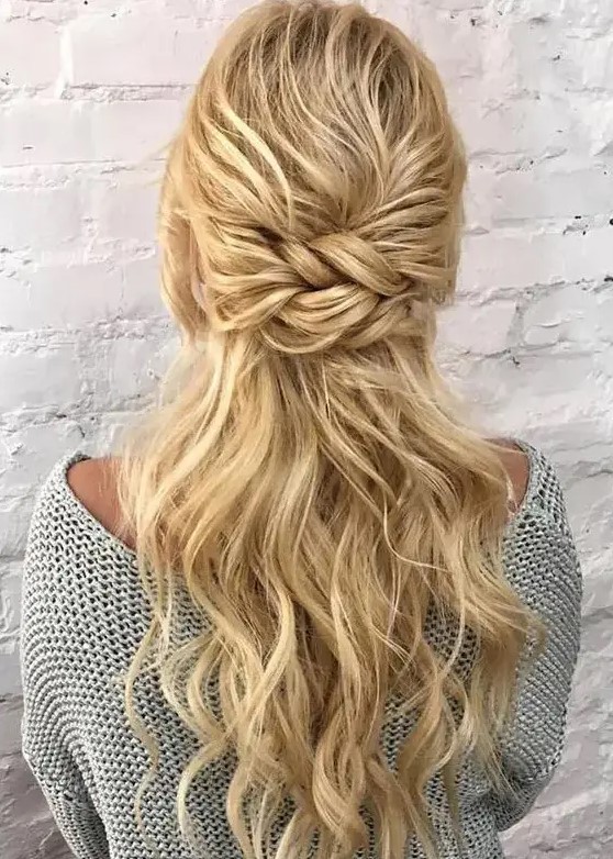 An eye catchy half updo with a bump on top and a double twisted element, some waves down is a stylish and chic idea