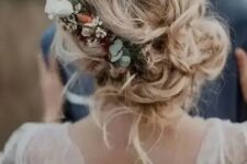 30 messy and loose wedding low updo with waves and locks down and with a floral accent – neutral and blush blooms and greenery