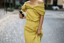 32 a pale yellow off the shoulder maxi dress with a ruffle skit, a draped neckline, a mini bag and statement earrings for a fall wedding