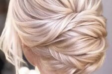 34 a beautiful blonde twisted low chignon with a bump on top and some locks down is a chic and formal idea