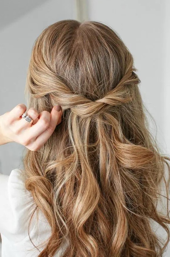 a beautiful half updo with a twisted braid and waves down is a cool idea for a boho braid or bridesmaid
