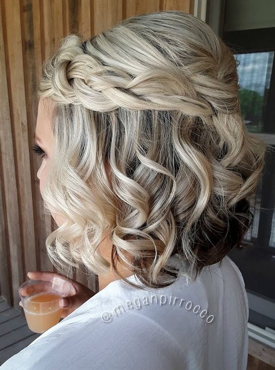 a boho half updo with a bump on top, a braided halo and waves down is a lovely and chic idea