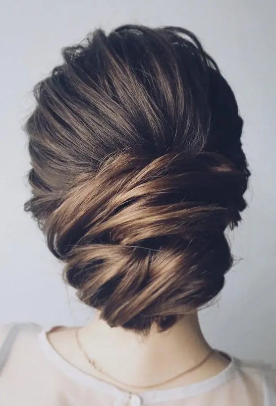 a chic low updo with a bump and much volume and texture for a feminine feel