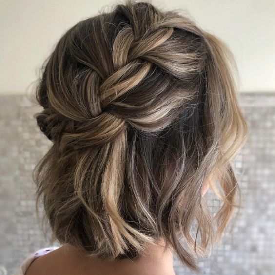 a loose braided halo half updo with waves and some volume is a chic and lovely idea for a boho wedding