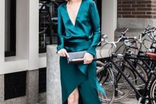 42 an emerald maxi dress with bell sleeves and a ruffled detail plus a plunging neckline, strappy shoes and a black clutch