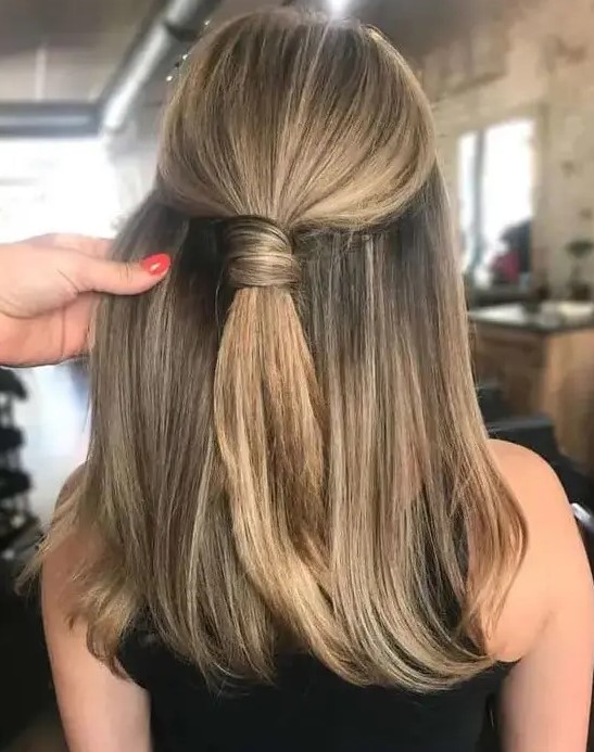 a stylish and cool half updo with a wrapped ponytail on top and straight hair down is a non-typical and very modern solution