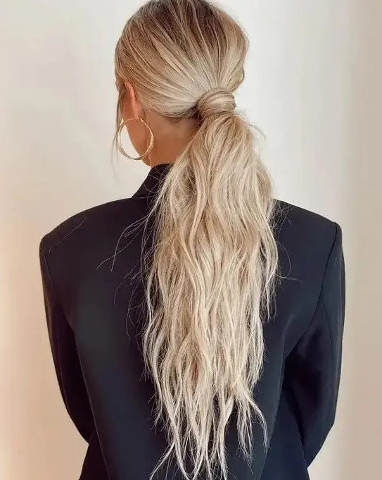 a classy messy and textural low ponytail with a messy top and hair wrapping it is a cool idea for a modern look