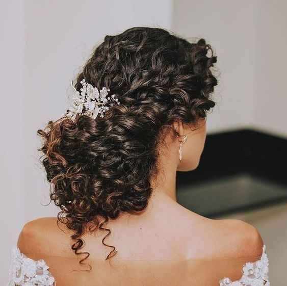 a curly half updo with a curly top and a rhinestone hairpiece is a catchy and elegant idea for a wedding