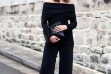 46 black culottes, a black strapless top with long sleeves, a black clutch and black mules