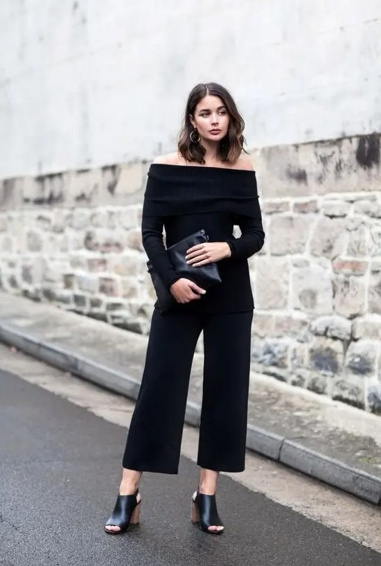 black culottes, a black strapless top with long sleeves, a black clutch and black mules