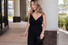 47 a black spaghetti strap jumpsuit with wideleg pants, a black clutch and a statement necklace