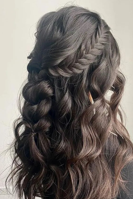 a cool boho half updo with a wavy bump, a braided halo and a losse braid down plus some waves