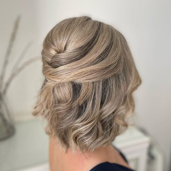 a pretty modern half updo with twisted touches and waves and a bump on top will fit medium hair length