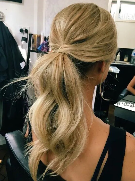 a simple and cute low ponytail with waves, locks down and a bump on top