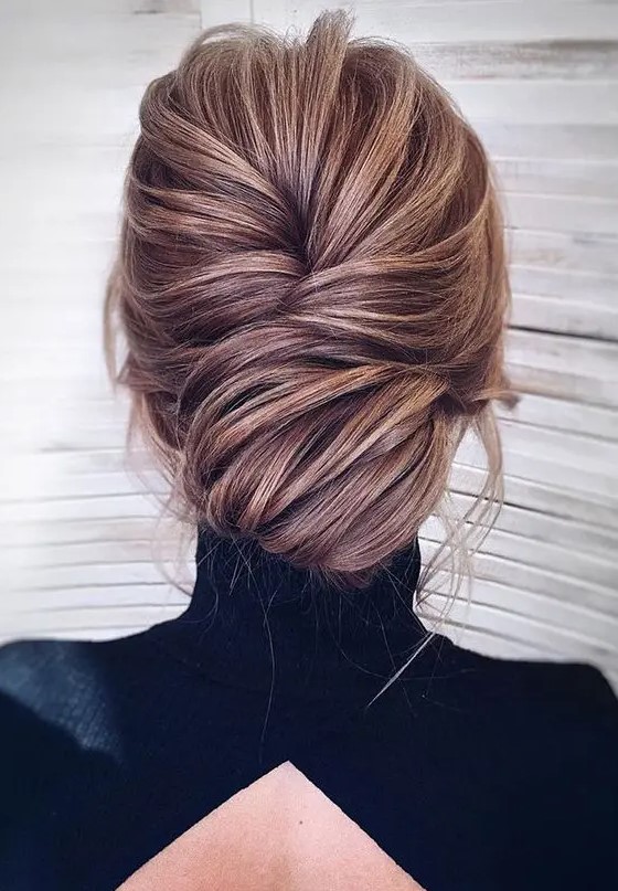 a super chic and elegant low chignon hairstyle with much volume and some bangs just wows