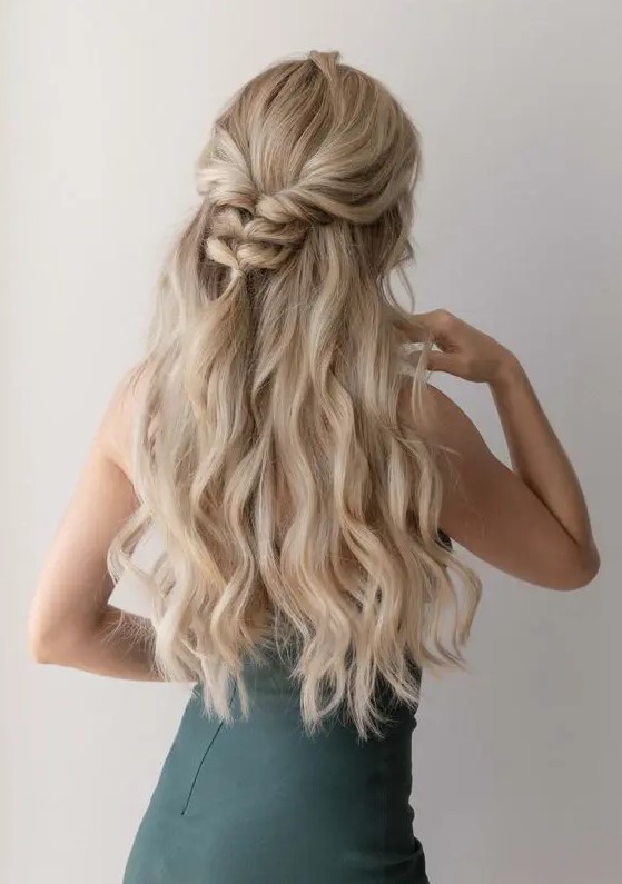 a half updo with a wavy top, a braided touch and waves down is a cool idea for a boho bride