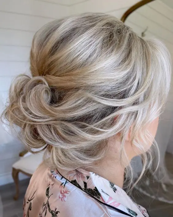 an elegant and relaxed updo on medium hair, with waves, a bump on top and waves framing the face is chic