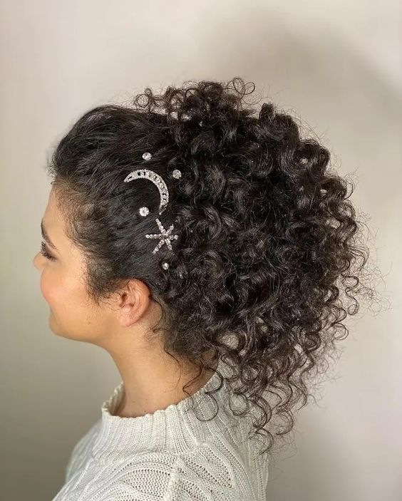 a curly high ponytail with a top accented with rhinestone hair pins all over is a cool idea for a wedding