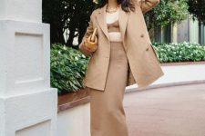 64 a trendy outfit with a crop top and matching midi skirt, an oversized tan blazer, black shoes and a bag