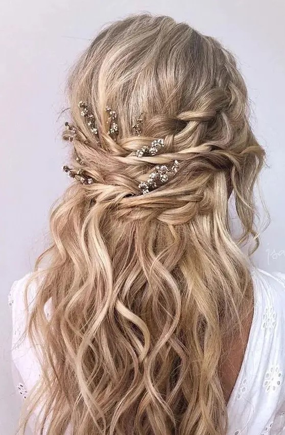 a pretty wavy twisted half updo with waves, fresh blooms and waves down and a bump is a cool rustic or boho solution