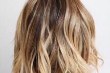 a beautiful and a bit messy long bronde bob with golden and bleached blonde balayage and a darker root is chic