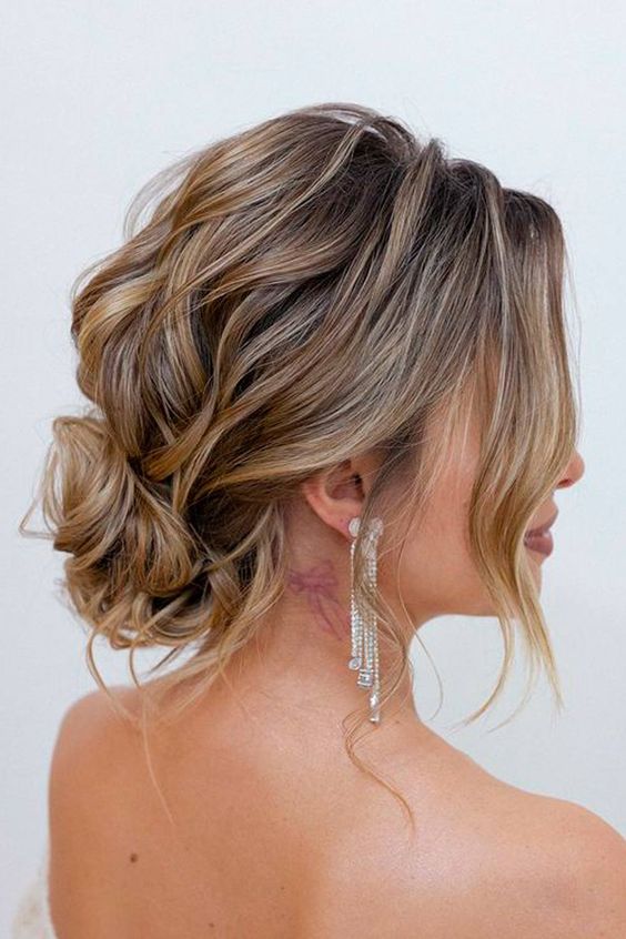 a beautiful and messy low bun with a wavy top and a wavy bun, some locks framing the face is fabulous