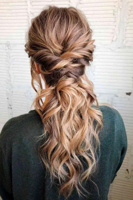 a beautiful low ponytail with twists and a wavy top is a beautiful way to show off your wavy locks at a boho wedding
