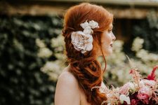 a beautiful messy side braid with a volume on top and some fabric flowers is a chic idea for a more relaxed bridal look